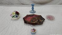 Wide shot of all vintage decorative pieces: flower bouquet, blue and white candlestick, Sydenstricker art glass bowl, pink glass bowl, and Limoges trinket box.
