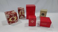 Original Estee Lauder boxes in various sizes with red and floral patterns, some labeled Cinnabar.