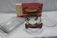 Photo of all glass bakeware including Lipper oval casserole dish in teak cradle and four Pyrex baking dishes.