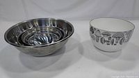 Three nested stainless steel mixing bowls and the vintage mushroom enamel bowl displayed side by side.