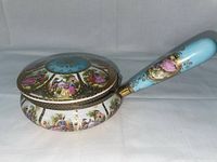 Side view showing the gold-encrusted porcelain body of the silent butler with multiple hand-painted courtship panels and detailed gold designs on lid and base.