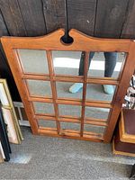 Full view of vintage rectangular mirror with wooden frame and 12-pane checker style glass sections, showing wood grain and carved top detail.