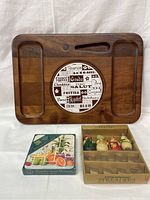 Front view of wooden cheese board with ceramic cheese-themed insert, Christmas spreaders in original box, and coasters in original box.