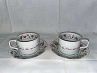 Photo showing both fortune telling cups and their decorated saucers side by side, highlighting inner rim designs and exterior cursive script.