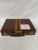 Closed brown vintage case with striped design and metal clasps.