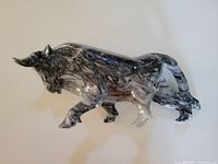 Side angle photo showing the full length and position of the carved marble bull sculpture.