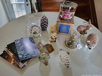 Full lot on table with candle, holder, pinecone, animal ornaments, glass tree dome, and cards.