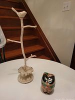 Metal jewelry tree with bird on branch and painted Sudha style cat box on table by stairs