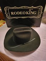Black Rodeo King cowboy hat displayed in front of the box showing the full hat and box branding.