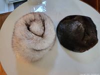 Top view of both fur hats placed side by side on a table