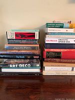 Stack of 18 books showing variety of titles and subjects such as history, literature, art, and dog breeds.