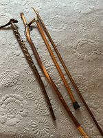 Overview photo showing all four walking sticks and canes laid on quilted surface, varying in length and detail.