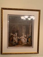 Framed coloured etching print showing multiple people in period clothing inside an ornate room.