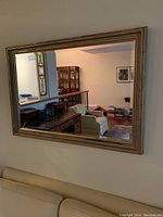 Full view of the horizontal mirror mounted above a couch, showing its size and reflective clarity.