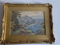 Full view of the framed watercolour coastal landscape painting by J. W. Burnett showing the ornate gold frame and the entire artwork under glass.