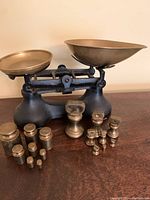 Full item with scale and all brass weights displayed on wood surface