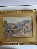 Full view of framed watercolour painting "The Wool Market" depicting historic market architecture and village scene.
