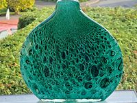 Front view of a flattened teardrop-shaped art glass vase with bubble pattern in blue and green hues.