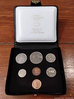 Photo of the full 1977 Canadian coin set displayed in a black presentation case lined with white under the lid stamped with Royal Canadian Mint logo and text in gold.