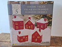 Box showing set of 5 ceramic red and white light-up Christmas village buildings
