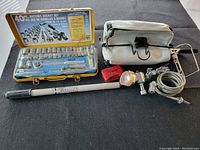 Wide angle view showing all items: ratchet socket set, bicycle bag, lights, tire pump, cable lock and water bottle holder.