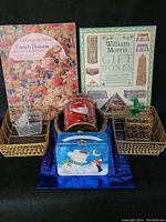 Wide view showing all items in the lot including books, baskets, canister, and lunch box.