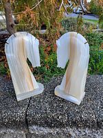 Two onyx horse head bookends shown outdoors on a stone surface, highlighting the natural stone striations and shape.