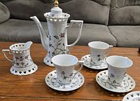 Full set displayed on table with three cups and saucers plus extra saucers and creamer