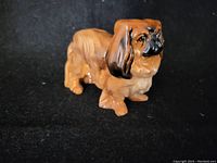 Side profile showing full body length of the Royal Doulton Pekinese dog figurine with detailed painting and glossy finish.