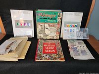 Overview image showing two hardcover stamp albums - Voyager and Majestic, two souvenir collections of Canadian stamps from 1978 and 1979 in protective covers, and multiple envelopes and loose stamps.