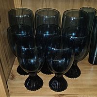 Front shelf close-up showing 8 blue Lennox glasses with textured, fan-like stems