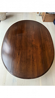 Top view of the coffee table showing the oval wooden surface with a dark cherry stain finish.