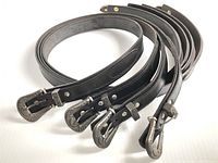 Four black leather belts arranged side by side showing the length and buckles clearly.