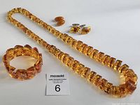 Complete vintage amber jewelry lot showing necklace, bracelet, cuff links, and earrings arranged together