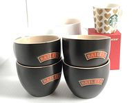 Set of four matte black Baileys ceramic cups stacked together with the Baileys logo visible