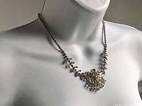 Front view of necklace worn on display bust showing overall design and tapering chain.
