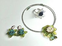 All three pieces - choker necklace with beaded flower pendant, earrings, and ring displayed on white background