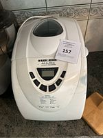 White Black & Decker All-in-One Automatic Bread Maker with digital display and control buttons, front view on kitchen counter.