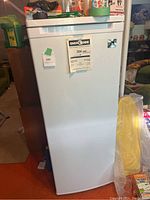 Front view of closed white upright freezer with EnerGuide 304 kWh/yr sticker visible