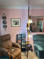 Full height lamp installed between floor and ceiling in living room setting between two recliners