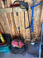 Power washer with hose and spray gun, showing general condition and setup.