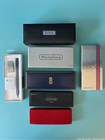 Top view of six pen boxes from various brands like Duke, Montefiore, Sheaffer, Ceramic, and Centennial.