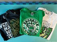Three concert t-shirts folded and stacked showing logos of Dropkick Murphys and Webster Hall