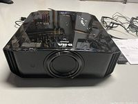 Front view of projector showing lens and top glossy surface