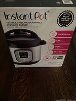 Front view of the Instant Pot box showing brand, model, and key features such as 7-in-1 multi-use functions, 8 quart capacity, and programmable pressure cooker technology.