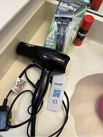 View of Conair blow dryer with cord, pack of Gillette disposable razors and Gillette shaving cream in red canister
