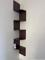 Full view of unique zigzag corner display shelf mounted on wall