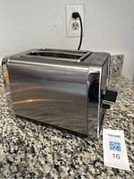 Side view of the Hamilton Beach 2-slot toaster showing polished chrome and stainless steel body with lever on side.