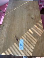 Top view of the wood kitchen table showing surface and wood grain with lot tag