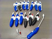 14 Comfort Wand spray handles laid out on a surface showing both blue and black models with white attachments.